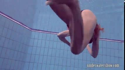 Молодая брюнетка нырнула в бассейн, сняла черные трусики и стала плавать голой, позируя перед видеокамерой